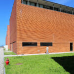 Adalberto Dias's design of the Autonomous Section of Mechanical Engineering at the University of Aveiro showcasing a composite material structure with brick elements, daylighting features, and a campus setting.