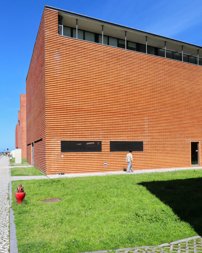 Pedro Ramalho and Luis Ramalho's design of the Autonomous Section of Industrial Management and Engineering at the University of Aveiro, showcasing a modern urban design with a sleek glass façade and expansive public space.