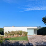 Alcino Soutinho's 10 Villas at Bom Sucesso Resort showcasing modern architecture with a focus on landscaping, featuring conifers and shrubs integrated into the design.