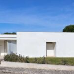 Álvaro Siza Vieira's 14 Villas at Bom Sucesso Resort showcasing a modern concrete facade with composite materials, featuring distinct wall structures and shaded areas.