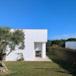 Álvaro Siza Vieira's 14 Villas at Bom Sucesso Resort showcasing modern residential architecture with landscaped gardens, grass lawns, and shrubbery in a daytime setting.