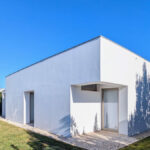 Álvaro Siza Vieira's 14 Villas at Bom Sucesso Resort showcasing modern architecture with composite material structures, surrounded by landscaped lawns and shrubs under daylight.