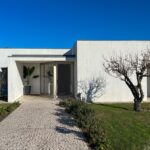 Álvaro Siza Vieira's 14 Villas at Bom Sucesso Resort showcasing modern architecture with concrete walls, landscaped gardens, and a neatly paved driveway.