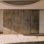 Álvaro Siza Vieira's Commercial Area at Bom Sucesso Resort showcasing a modern design with concrete walls, tile flooring, and ample daylighting through large windows.