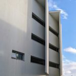 Álvaro Siza Vieira's Faculty of Architecture of the University of Porto - FAUP showcasing a high-rise building with composite materials and glass elements, emphasizing daylighting during daytime.