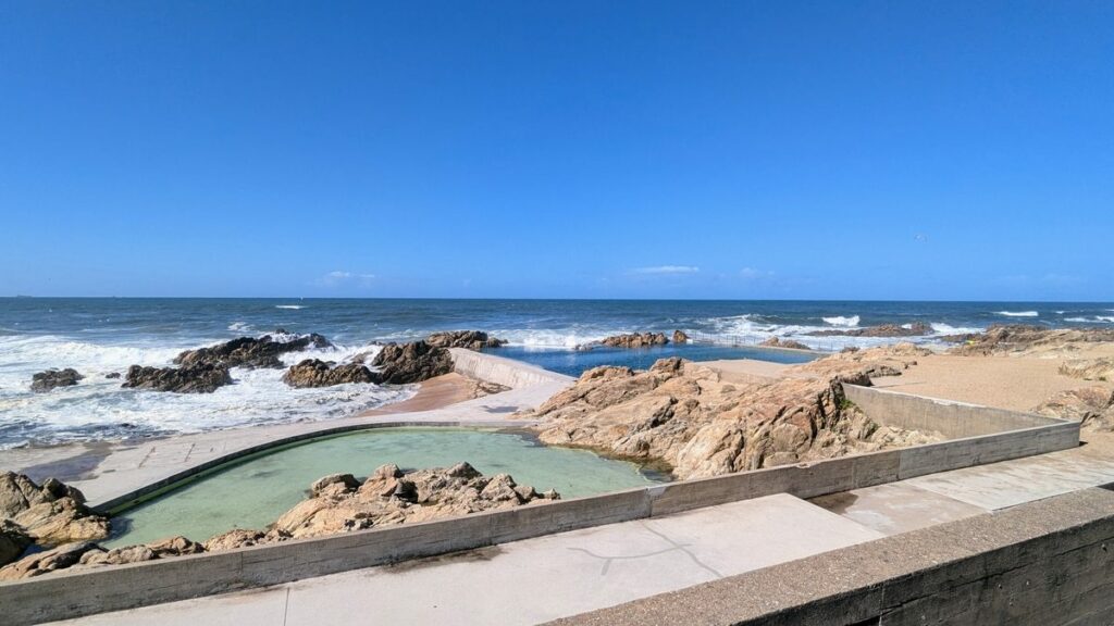 Álvaro Siza Vieira's Leça da Palmeira Seafront Avenue Urban Plan showcasing a modern design with concrete structures, a swimming pool, palm trees, and daylighting elements.