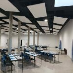 Álvaro Siza Vieira's Nave Lagoa at Bom Sucesso Resort showcasing a symmetrical interior design with composite material flooring, a glass ceiling, and engineering elements.