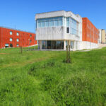 Bernardo Ferrão's Institute of Electronic Engineering and Telematics at the University of Aveiro showcasing a modern design with a glass façade, expansive lawn, and integrated urban design elements.