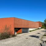 Carrilho da Graça's 14 Houses at Quinta do Bom Sucesso Resort showcasing a modern design with concrete walls and brickwork elements.
