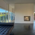 Carrilho da Graça's 14 Houses at Quinta do Bom Sucesso Resort showcasing a modern interior with wood flooring, glass elements, and contemporary lighting.