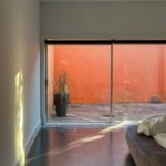 Carrilho da Graça's 14 Houses at Quinta do Bom Sucesso Resort showcasing a modern design with extensive use of glass for daylighting, brown hardwood flooring, and clean varnished surfaces.