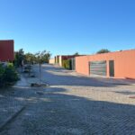 Carrilho da Graça's 14 Houses at Quinta do Bom Sucesso Resort showcasing a modern design with concrete structures, asphalt driveways, and landscaped walkways.
