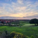 Carrilho da Graça's 14 Houses at Quinta do Bom Sucesso Resort showcasing modern architecture with a minimalist design, surrounded by grassland and a serene horizon at dusk.