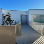 David Chipperfield's 4 Villas at Bom Sucesso Resort showcasing a modern urban design with concrete and aluminium structures, featuring balconies and daylighting elements in a residential area.