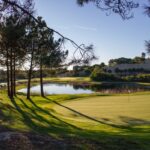 Donald Steel's Bom Sucesso Resort Golf Course showcasing a vast plain with a meticulously designed golf course layout, featuring a serene lake and lush green fairways.