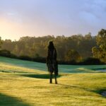 Donald Steel's Bom Sucesso Resort Golf Course showcasing a vast grassland landscape with natural sunlight illuminating the field in the morning.