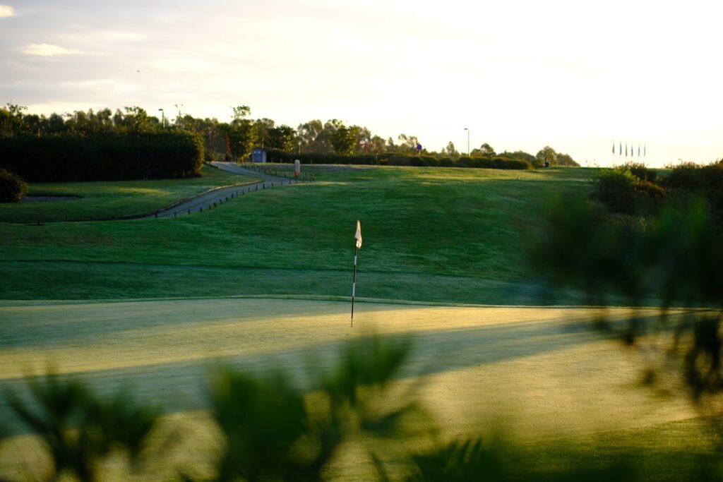 Donald Steel's Bom Sucesso Resort Golf Course showcasing lush grasslands, a serene lake, and meticulously maintained fairways surrounded by natural meadows.