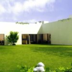 Eduardo Souto de Moura's 13 C-Shaped Villas at Bom Sucesso Resort showcasing modern architecture with a focus on landscaped gardens, artificial turf, and expansive lawns.