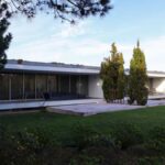 Eduardo Souto de Moura's 6 Row Houses at Bom Sucesso Resort showcasing a modern design with concrete structures, landscaped gardens, and evergreen conifers providing shade.