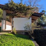 Fernando Távora's Tennis Pavilion of Quinta da Conceição showcasing a wooden structure with shaded walkways, surrounded by landscaped gardens and daylighting elements.