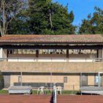 Fernando Távora's Tennis Pavilion of Quinta da Conceição showcasing a sports venue with a shaded area surrounded by trees.