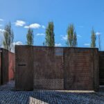 Gonçalo Byrne's Rusty Gates - 25 Row Houses at Bom Sucesso Resort showcasing composite material and concrete structures with visible shadows and mesh elements.