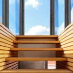 Gonçalo Byrne's Urban Requalification of São Martinho do Porto showcasing a blend of wood and metal materials with hardwood floors, glass elements, and a modern staircase design.