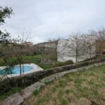 Guilherme Machado Vaz's House in Afife showcasing a modern design with a lush garden, expansive backyard, and well-maintained lawn integrated into the landscaping.