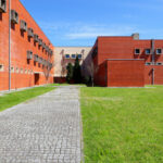 Jorge Kol de Carvalho's Department of Communication and Arts, University of Aveiro, showcasing urban design with brickwork, a lawn, and artificial turf on the campus.