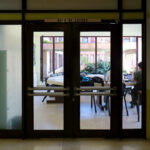 José Carlos Loreiro's Department of Biology I at the University of Aveiro showcasing a modern interior design with glass doors, metal elements, and strategic lighting enhancing transparency and spaciousness.
