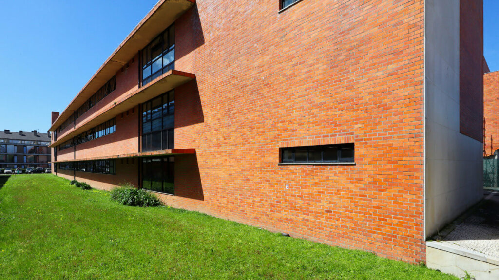 José Maria Lopo Prata's CEFASI-Centre for Specialization and Advanced Training for Services and Industry at the University of Aveiro showcasing a modern brick and composite material structure with daylighting features on the campus.