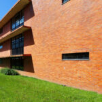 José Maria Lopo Prata's CEFASI-Centre for Specialization and Advanced Training for Services and Industry at the University of Aveiro showcasing a modern brick and composite material structure with daylighting features on the campus.