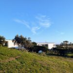 Josep Llinás's 6 Villas at Bom Sucesso Resort showcasing a modern design with expansive green lawns and surrounding shrubbery in a rural estate setting.