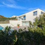Josep Llinás's 6 Villas at Bom Sucesso Resort showcasing modern estate design with landscaped surroundings, palm trees, and balconies.