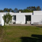 Manuel Aires Mateus's 7 Row Houses at Bom Sucesso Resort showcasing a modern design with concrete structures, landscaped gardens, and expansive lawns.