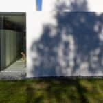 Manuel Aires Mateus's 7 Row Houses at Bom Sucesso Resort showcasing a minimalist design with concrete and plaster materials, featuring grey tones and strategic daylighting elements.