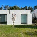 Manuel Aires Mateus's 7 Row Houses at Bom Sucesso Resort showcasing a minimalist design with concrete structures, landscaped gardens, and expansive lawns.