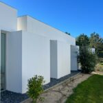 Manuel Aires Mateus's 7 Row Houses at Bom Sucesso Resort showcasing a modern design with concrete and composite materials, featuring shaded areas and integrated landscaping for enhanced daylighting.