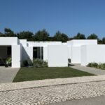 Manuel Aires Mateus's 7 Row Houses at Bom Sucesso Resort showcasing urban design with concrete structures, composite materials, and landscaped courtyards.