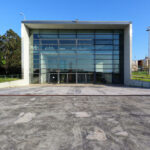 Manuel Aires Mateus and Francisco Aires Mateus' "Canteen and Dining Halls, University of Aveiro" showcasing a modern concrete structure with extensive use of composite materials, daylighting, and steel elements, resembling a corporate headquarters with shaded areas.