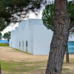 Manuel Aires Mateus's Primary School in Vila Nova da Barquinha showcasing a minimalist design with clean lines and shaded areas under a clear daytime sky.