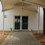 Manuel Aires Mateus's Primary School in Vila Nova da Barquinha showcasing a modern design with a prominent canopy and outdoor structure providing shade and daylighting features.
