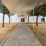 Manuel Aires Mateus's Primary School in Vila Nova da Barquinha showcasing a minimalist design with a prominent shaded walkway and distinct shadow patterns.