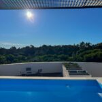 Manuel Graça Dias and Egas José Vieira's 13 Round Houses at Bom Sucesso Resort showcasing a modern design with composite materials, a swimming pool, outdoor furniture, and eco-friendly features.
