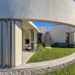 Manuel Graça Dias and Egas José Vieira's 13 Round Houses at Bom Sucesso Resort showcasing Brutalist architecture with concrete structures, composite materials, and integrated landscaping under daylight.