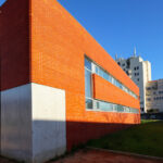 Maria Emília Pedroso Lima's design of the Higher Institute of Accounting and Administration, University of Aveiro, showcasing a brick façade with orange brickwork and daylighting elements.