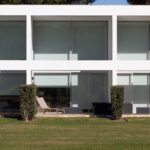 Nuno Graça Moura's 24 Row Houses at Bom Sucesso Resort showcasing a modern design with concrete structures, glass façades, balconies, and landscaped courtyards.