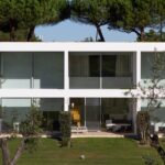Nuno Graça Moura's 24 Row Houses at Bom Sucesso Resort showcasing a modern design with concrete structures, shaded balconies, ample daylighting, and landscaped courtyards.