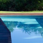 Nuno Graça Moura's 24 Row Houses at Bom Sucesso Resort showcasing a modern design with a blue swimming pool, composite material structures, shaded areas, and eco-friendly features like hardwood elements.