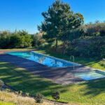 Nuno Graça Moura's 24 Row Houses at Bom Sucesso Resort showcasing a modern design with a blue swimming pool, landscaped garden, and expansive lawn in the backyard.